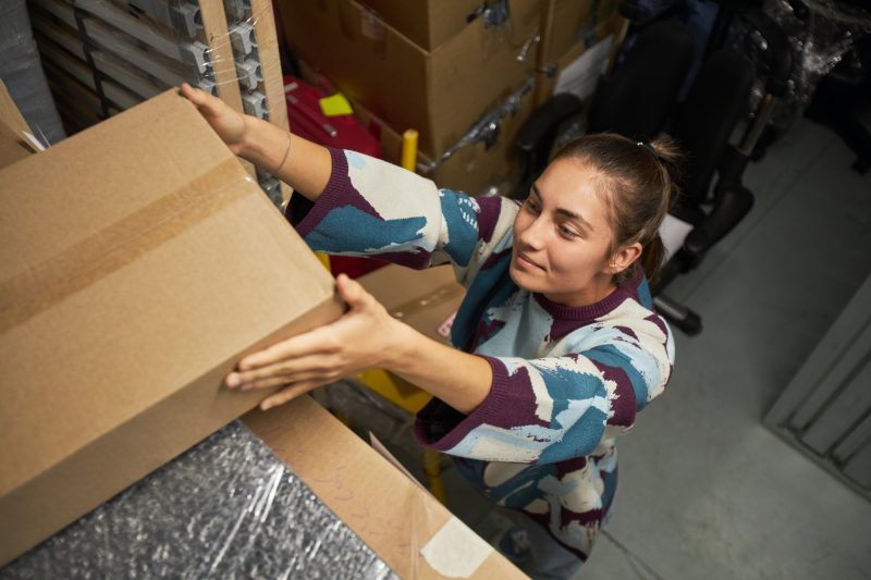 Woman Storing Boxes in Storage Unit